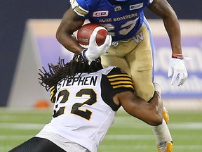 Winnipeg Blue Bombers defensive back Kevin Fogg (right) is tackled by Hamilton Tiger-Cats defensive back Courtney Stephen on Wednesday night. (Brian Donogh/Winnipeg Sun)