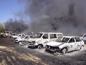 Burnt out vehicles stand in a parking lot in Barragem da Povoa eastern Portugal Wednesday Aug. 3, 2016. The parking lot at  open-air music and dance festival in eastern Portugal resembles a vehicle graveyard after a wildfire gutted 422 cars.  Authorities said there were no casualties in the blaze that broke out Wednesday, forcing the evacuation of some 4,000 people at the festival.  (Jose Manuel Costa via AP)