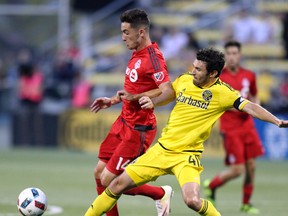 TFC midfielder Jay Chapman fights for the ball with Columbus Crew defender Michael Parkhurst during their game last month. (AP)