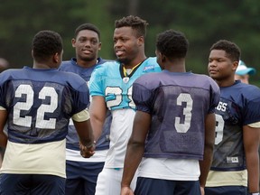 Carolina Panthers' Jonathan Stewart, center, greets members of the Spartanburg High School football team during an NFL training camp practice in Spartanburg, S.C., Thursday, Aug. 4, 2016. The high school participated in pre-practice stretching with the Panthers and held their own practice on an adjacent field. (AP Photo/Chuck Burton)