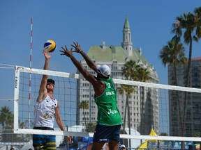 Chaim Schalk of Canada (left) spikes the Mikasa against Evandro Goncalves of Brazil during the FIVB Long Beach Grand Slam on July 25, 2014, in Long Beach, Calif.