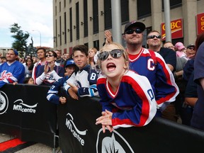 A young fan cheers as the National Hockey League announce the rosters at a Tim Hortons NHL Heritage Classic press event at Winnipeg's Portage and Main intersection on Friday, August 5, 2016. THE CANADIAN PRESS/John Woods