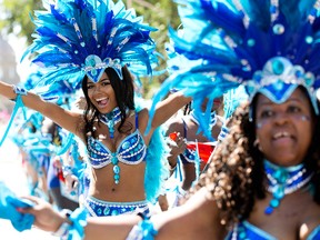 Dancers from the Sykotik Mas entry in the Cariwest Parade dance through downtown Edmonton Alta. on Saturday Aug. 8, 2015. David Bloom/Postmedia Network