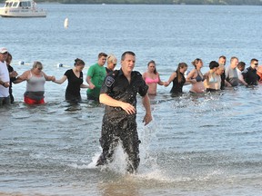 A Barrie police officer rushes from the water at Centennial Beach, Friday evening, after a young male went missing at approximately 6 p.m. Police, firefighters and paramedics were assisted by beach-goers who helped form a human chain during the search for the young man, who was pulled from the water at approximately 6:45 p.m. without any vital signs.
IAN MCINROY/BARRIE EXAMINER/POSTMEDIA