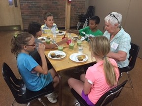 Kids at the Chefs in Training summer camp share a meal and some conversation with volunteer Judy Chivers. Pictured (left to right) are: Kiara Cyr, Emily Russell, Bryce Elliott, Tyrese Huggins, and Chivers. (Submitted)
