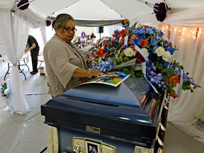 A woman pays her last respects to Dylan Laboucan (17-years-old) and Cory Grey (19-years-old), the two Whitefish River First Nations teens who were found dead in July 2016 near the Atikameg settlement in northern Alberta. The funeral for both teens was held on the Whitefish Lake First Nation Reserve on Friday August 5, 2016. Photo by Larry Wong/Postmedia