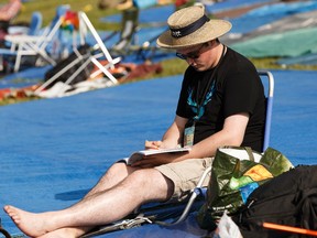 Jared Byers colours in his book during a quiet moment at the Edmonton Folk Music Festival at Gallagher Park in Edmonton, Alberta on Friday, August 5, 2016. Ian Kucerak / Postmedia