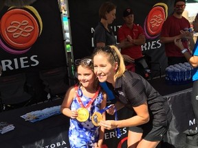 Olympic gold medallist Kaitlyn Lawes shows off her Olympic gold medal with a young fan during the Zoolympics at Assiniboine Park Zoo on Saturday, August 6, 2016.