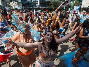 People take part during the Cariwest Festival's Great Parade along Jasper Avenue in Edmonton, Alta., on Saturday, Aug. 6, 2016. (Codie McLachlan/Postmedia)