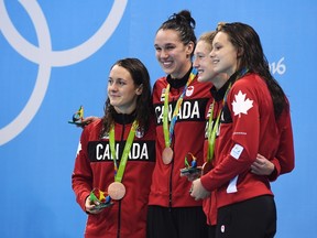 The Canadian women's 4x100-metre freestyle relay team, left to right, Sandrine Mainville, Chantal van Landeghem, Taylor Ruck and Penny Oleksiak receive their bronze medal at the 2016 Summer Olympics, in Rio de Janeiro, Brazil, on Saturday, Aug. 6, 2016. (Frank Gunn/The Canadian Press)