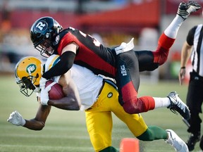 Redblacks’ John Boyett tackles Edmonton Eskimos receiver Adarius Bowman during the first half of their CFL game at TD Place.