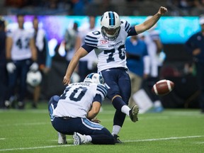 Toronto Argonauts' Lirim Hajrullahu kicks a field goal as quarterback Logan Kilgore holds during the first half of a CFL football game in Vancouver, B.C., on July 7, 2016. (THE CANADIAN PRESS/Darryl Dyck)