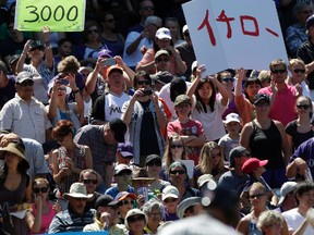 Fans hold signs as Miami Marlins right fielder Ichiro Suzuki waits to bat in the first inning of a baseball game in Denver on Aug. 7, 2016. (AP Photo/Joe Mahoney)