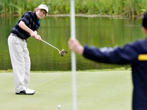 en Lucky watches his putt as Cameron Hughes gets ready to pull the pin during the MacDonald Ross Jr. Classic Golf Tournament at Blackhawk Golf Club in Edmonton in 2010.