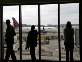 In this April 14, 2015, file photo, Delta Air Lines passengers watch as a Delta plane taxis at Atlanta's Hartsfield International Airport in Atlanta. Delta Air Lines grounded flights scheduled to leave Monday, Aug. 8, 2016, after experiencing unspecified systems issues. (AP Photo/Charles Rex Arbogast, File)