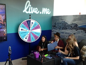 In this Thursday, June 23, 2016, photo, Erick Armas, left, captures video of, from right, Jordan Hoyle, Violet Summersby, George Padilla and Sue Evelyn Gil, who were live broadcasting from the live.me booth at VidCon, an annual convention for the fans of stars from YouTube, Vine, Instagram and other video platforms, at the Anaheim Convention Center in Anaheim Cailf.  (AP Photo/Ryan Nakashima)