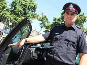 Const. Giovanni Sottosanti poses with a police cruiser. Sarnia police are encouraging residents to lock their vehicles after thefts from unmarked cars have been frequent this spring and summer. (Tyler Kula/Sarnia Observer/Postmedia Network)