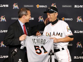 Jeff Idelson, left, president of the National Baseball Hall of Fame and Museum, and Miami Marlins’ Ichiro Suzuki smile as Suzuki donates items from the game in which he recorded his 3,000th hit during a news conference, Monday, Aug. 8, 2016, in Miami. (AP Photo/Wilfredo Lee)