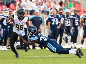 Hamilton Tiger-Cats receiver Anthony McClung is tackled by Toronto Argonauts defender Thomas Gordon, right, during CFL pre-season play in Toronto, Saturday June 11, 2016. (THE CANADIAN PRESS/Mark Blinch)