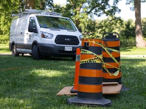 Pylons wrapped in caution tape stand over plywood, used to cover a septic tank Monday after a weekend incident in which a three-year-old boy was rescued after falling into the opening in London?s Greenway Park. Below is a properly secured septic tank in the same park. (CRAIG GLOVER, The London Free Press)