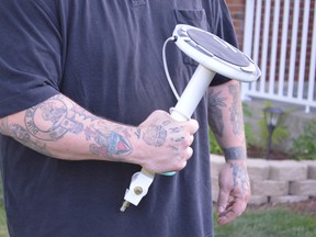 Tim Ranger holds the lamp he used to confront an invader on Saturday night at his New Sudbury home. The Westmount Avenue resident also struck the intruder with the lid of a toilet tank and butt end of a buck knife to protect his two young children. (Jim Moodie/Sudbury Star)