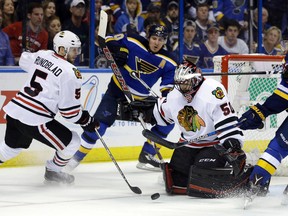 Blackhawks goalie Corey Crawford (right) keeps his eyes on a loose puck along with teammate David Rundblad and Blues forward Alexander Steen (centre) during NHL playoff action in St. Louis on April 25, 2016. The Blues will host the Blackhawks in the NHL's Winter Classic on Jan. 2, 2017. (Jeff Roberson/AP Photo)