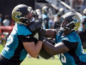 Jacksonville Jaguars offensive tackles Josh Wells, left, and Kelvin Beachum perform a drill during NFL football training camp, Friday, July 29, 2016, in Jacksonville, Fla. (AP Photo/John Raoux)
