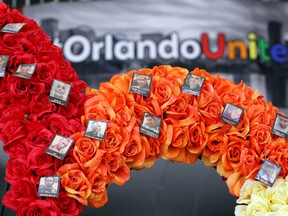 A heart-shaped wreath bears the 49 photos of the victims from the Pulse nightclub massacre, in the atrium of Orlando City Hall, Thursday, Aug. 4, 2016. The wreath was placed at city hall to raise continued awareness for the OneOrlando fund, to benefit the victims of the shootings and their families. (Joe Burbank/Orlando Sentinel via AP)