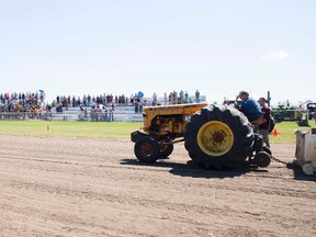 Rob Repp is joined by spectors in a moment of silence for his son Christopher at the Vermilion Fair's Antique Tractor Pull event on Friday, July 29, 2016, in Vermilion, Alta. Taylor Hermiston/Vermilion Standard/Postmedia Network.