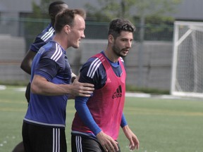 FC Edmonton captain Albert Watson, left, talks with new signing Nicolas Di Biase at practice on Tuesday, Aug. 9, 2016.