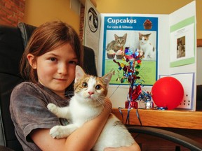 Ella Hickey, sitting with one of her two new kittens Honey, is holding a cupcake bake sale fundraiser instead of a birthday party to celebrate her 10th birthday on Aug. 19 and to help raise money for Spay Neuter Kingston Initiative's (SNKI) high-volume, reduced cost spay/neuter clinic project in Kingston. (Julia McKay/The Whig-Standard)