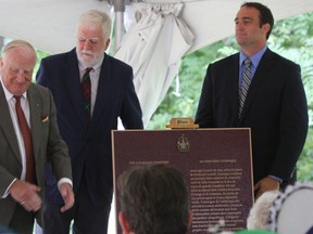 (From left) Charles Simonds, president of the Cataraqui Cemetary, historian John Grenville and Mark Gerretsen, member of Parliament for Kingston and the Islands,  unveil the commemorative plague that signifies the Cataraqui Cemetery as a national historic site in Kingston. (Steph Crosier/The Whig-Standard)