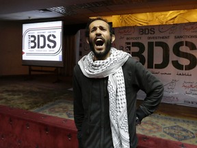 An Egyptian man shouts anti-Israeli slogans in front of banners with the Boycott, Divestment and Sanctions (BDS) logo during the launch of the Egyptian campaign that urges boycott, divestment and sanctions against Israel and Israeli-made goods, at the Egyptian Journalists’ Syndicate in Cairo, Egypt. (AP Photo/Amr Nabil, File)