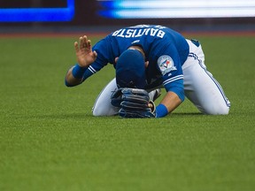 Toronto Blue Jays right fielder Jose Bautista (19) reacts after hurting himself on a routine throw against the Tampa Bay Rays in Toronto on Tuesday, August 9, 2016. (THE CANADIAN PRESS/Nathan Denette)