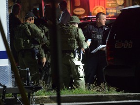 Police are pictured in a parking lot across the street from a house in Strathroy, Ont., on Aug. 10, 2016. A terrorism suspect died during a police operation in the southern Ontario town. (MORRIS LAMONT/The London Free Press/Postmedia Network)