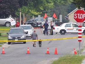 Police gather evidence outside of a house in Strathroy Ont., Thursday, August 11, 2016. THE CANADIAN PRESS/ Dave Chidley