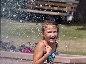 Bailey Schram, 11, cools off in the Civic Square fountain on Sunday. Temperatures are  expected to be hot and humid once again this week and into the weekend.