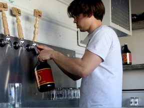 Head brewer Dalen Landis prepares a refill of beer for a customer at Grain Bin Brewing Company. Jocelyn Turner/Daily Herald-Tribune