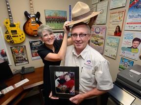 Lindsey McIntyre puts an autographed RCMP Stetson on husband David at the office of the Bethany?s Hope Foundation. The two are surrounded by mementoes of their fundraising efforts over the last 20 years. The foundation will be hosting the RCMP Musical Ride in London on the weekend. (MORRIS LAMONT, The London Free Press)
