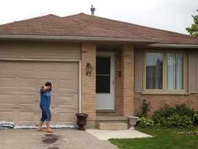 A woman walks in front of the garage at 43 Blanchard Cres., in northwest London. Police officers searched the home in connection with terrorism suspect Aaron Driver. (MIKE HENSEN, The London Free Press)