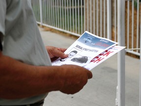 A Maryvale resident looks at information on a flyer about a recent string of shootings by a serial killer in Phoenix. (AP Photo/Beatriz Costa-Lima)