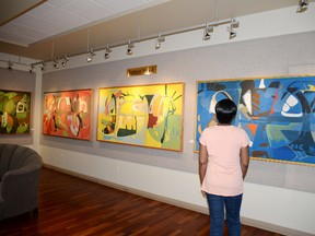 A woman admires the work of Edmonton artist Tanya Klimp during the opening reception for her “Big Boys” abstract paintings on Aug. 6. Four of Klimp’s pieces are on display at the Spruce Grove Art Gallery until Aug. 20. - Photo by Marcia Love