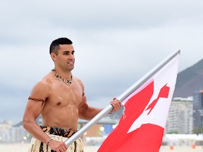 Pita Taufatofua of Tonga walks along the sand with his country's flag to the NBC Today show set at Copacabana Beach on August 8, 2016 in Rio de Janeiro, Brazil.  (Photo by Harry How/Getty Images)