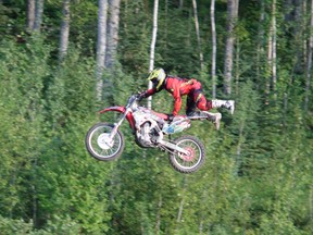 Motorcross racer Jamie Iwaschuk performs a trick on his bike while practicing at the Whiteridge Motorcross Park on Aug .3.