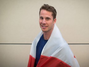 Corunna high jumper Derek Drouin poses with the Canadian flag in this June 16, 2016 file photo. Drouin will be competing in the Rio Olympics men's high jump qualifier Sunday at 7:30 p.m. (THE CANADIAN PRESS/Darryl Dyck)