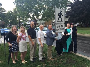 Jane Edwards, injury prevention specialist, London Health Sciences Centre (left) Alyssa Penny, Middlesex London Health Unit public health nurse, Edward Soldo, London’s director of roads and transportation, Coun. Michael van Holst, Mayor Matt Brown, Coun. Virginia Ridley and London Police Services Sgt. Amanda Pfeffer unveil London’s first pedestrian crossover. (Photo courtesy City of London)