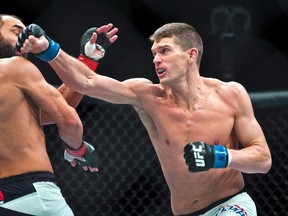 Welterweight Johny Hendricks takes a shot to the chin from Stephen Thompson during their UFC Fight Night 82 match at the MGM Grand Garden Arena in Las Vegas on Saturday, Feb. 6, 2016. (Las Vegas Sun via AP)