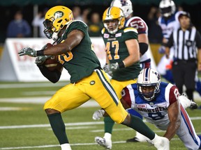 Edmonton Eskimos Deon Lacey (40) makes an interception and runs for a TD with under one minute left to play as Montreal Alouettes Nik Lewis (8) makes a diving effort during CFL action at Commonwealth Stadium in Edmonton Friday, August 11, 2016.