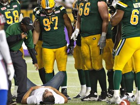 A fan lies injured after being hit by a player during second half CFL action between the Montreal Alouettes and Edmonton Eskimos, in Edmonton on Thursday, August 11, 2016.