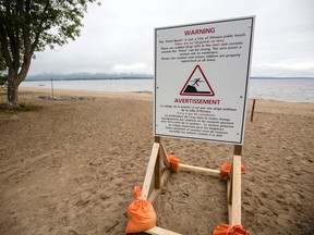 A sign warning of the dangers of swimming in this section of beach in Constance Bay, which is the scene where a 10-year-old boy drowned Saturday, is photographed Friday, August 12, 2016. (Darren Brown/Postmedia)
